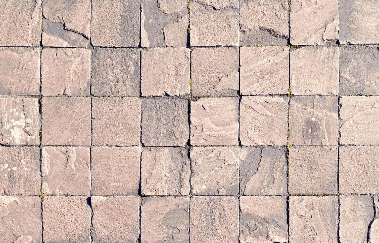 Abstract background of a grid of pinkish and gray stone cobblestones photo