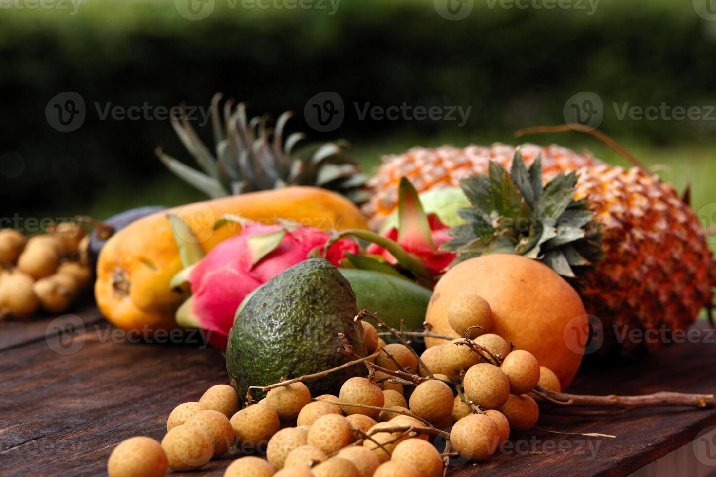 Fresh fruits and vegetables from Thailand and Bali beautifully arranged on a wooden table photo