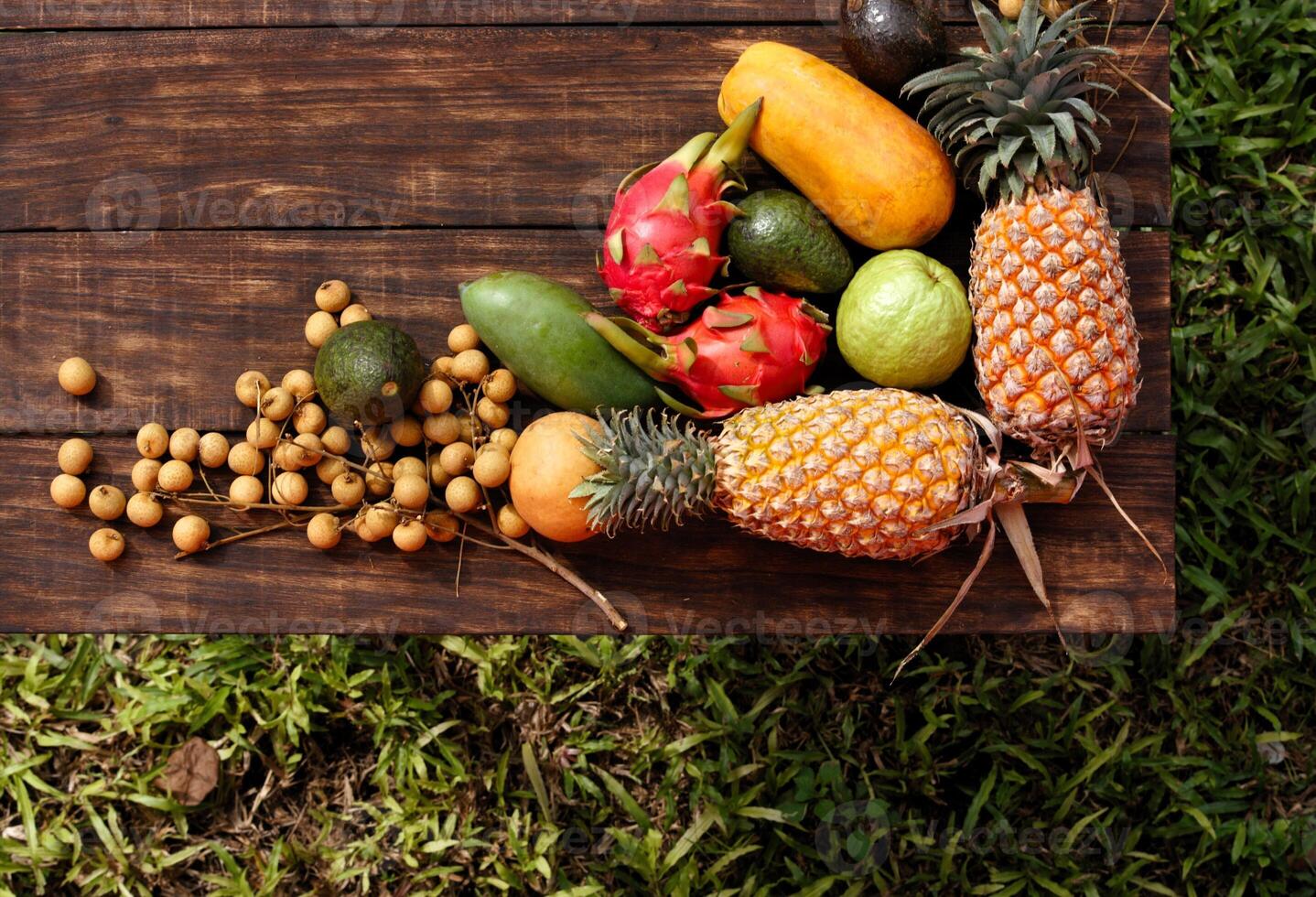 Fresh fruits and vegetables from Thailand and Bali beautifully arranged on a wooden table photo