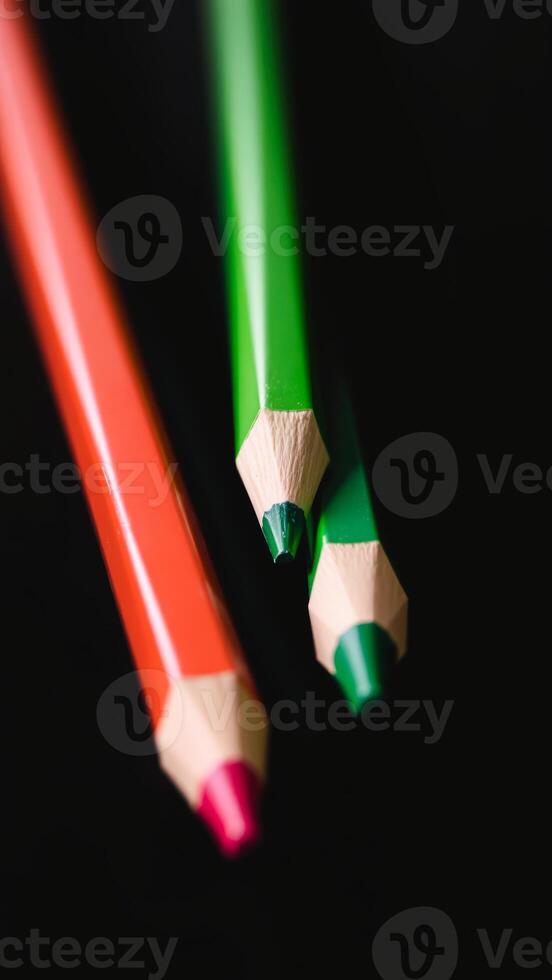 Closeup of Red and Green Colored Pencils on Black Background photo