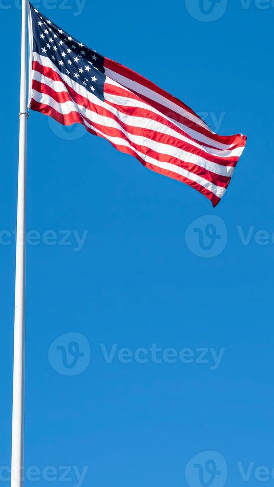 American Flag Waving in the Wind Against a Blue Sky photo