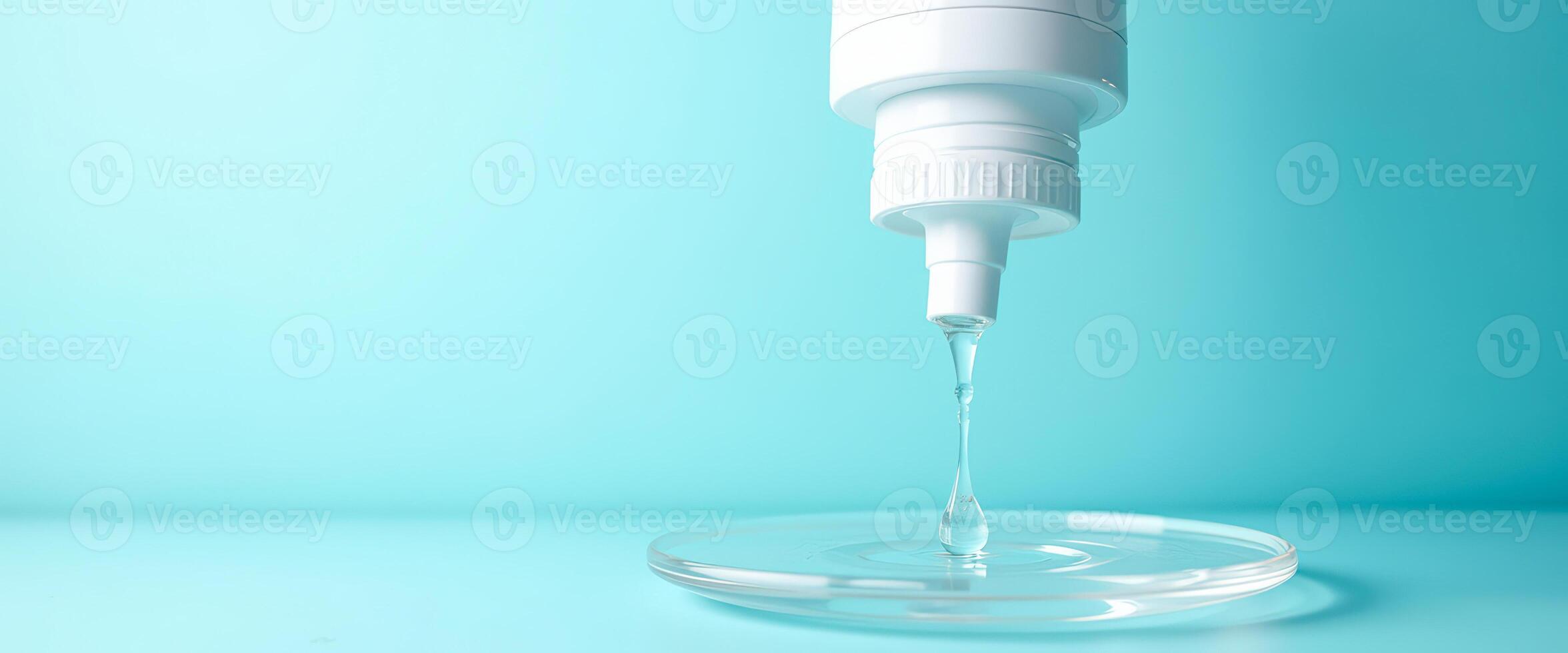 Droplet Falling into a Glass Dish on a Blue Background photo