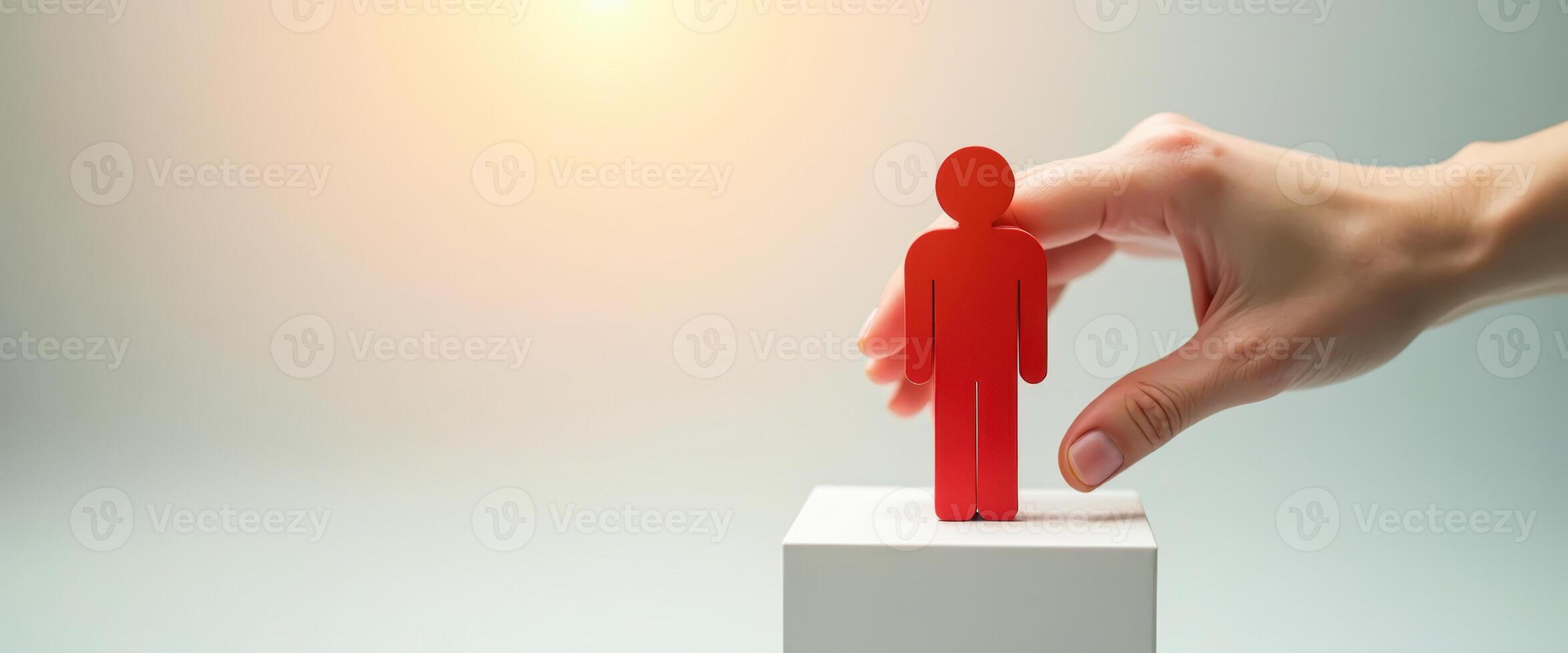Hand placing a red figure on a white platform photo