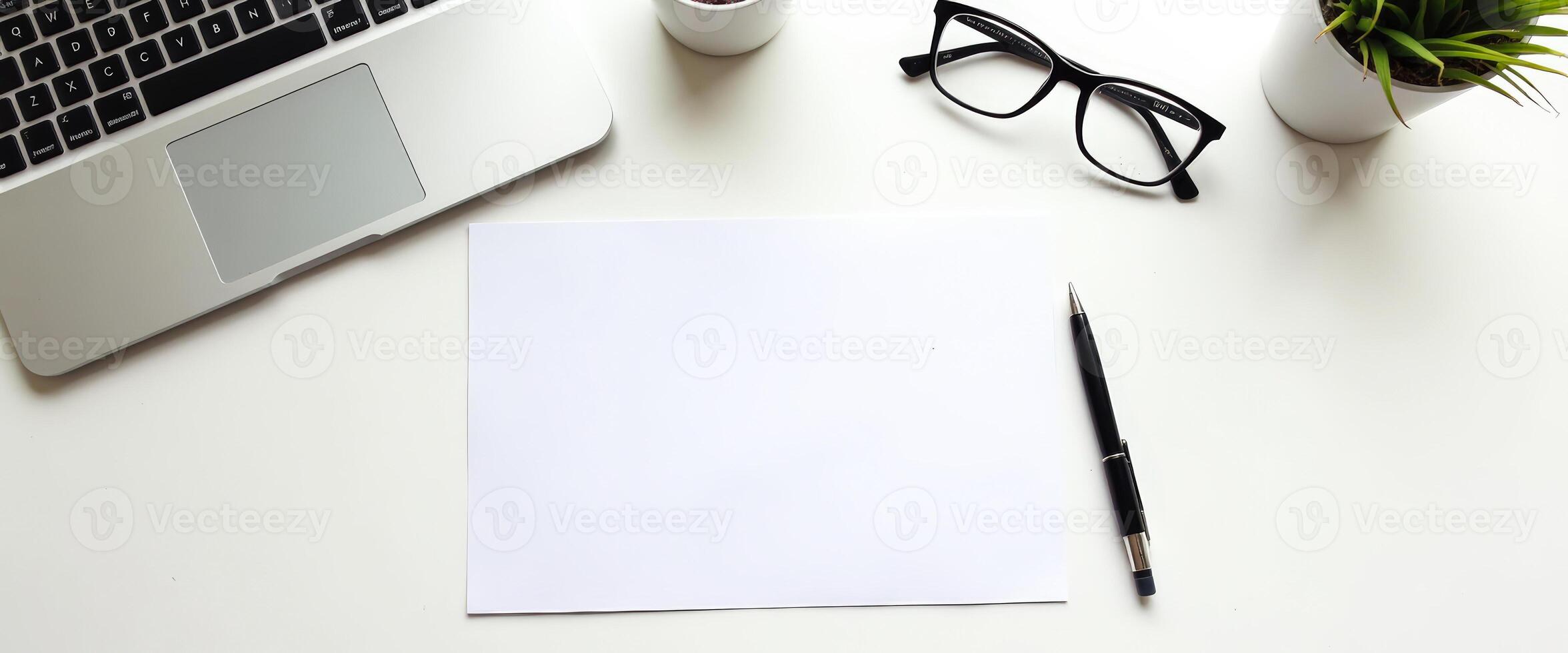 Clean White Desk with Laptop, Glasses, and Pen photo