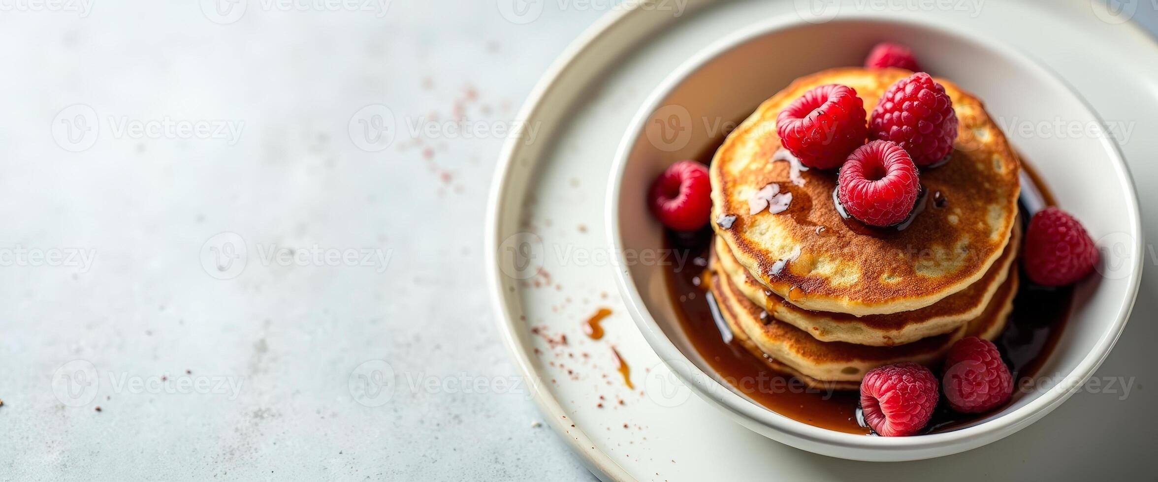 Stack of pancakes with raspberries and maple syrup photo