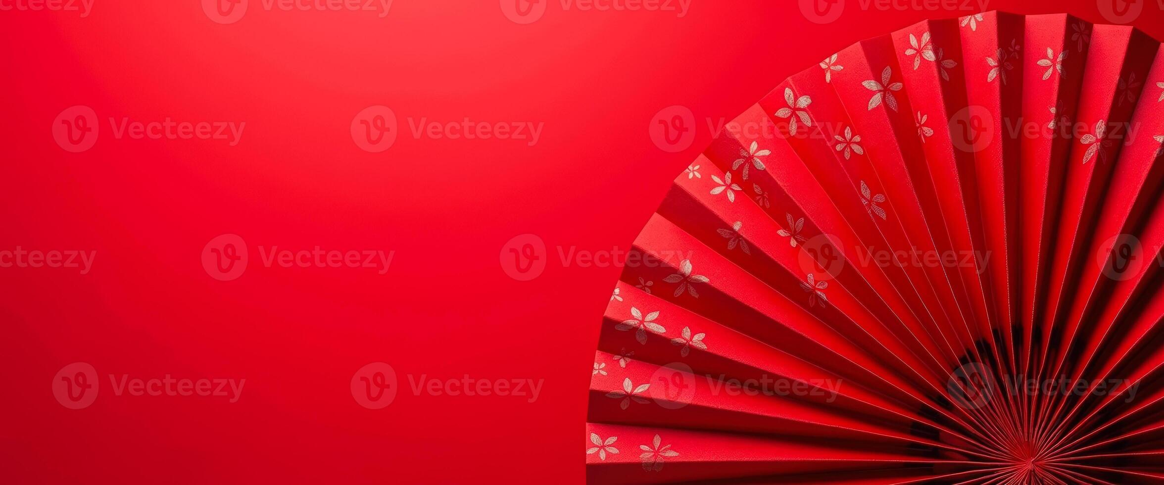 Red Folding Fan with Floral Pattern on Red Background photo