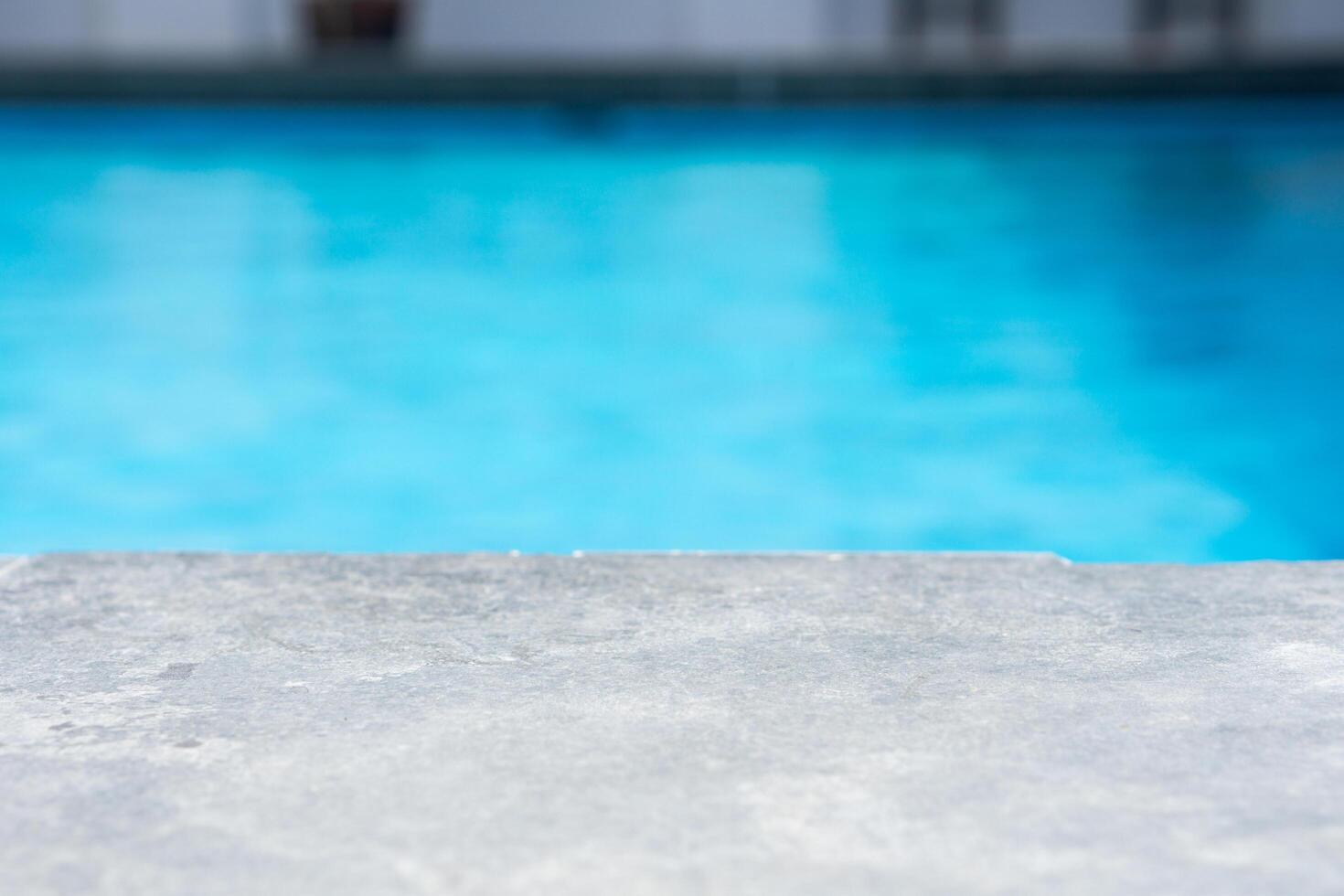 Empty grey ceramic table top and blurred swimming pool in tropical resort in summer banner background photo