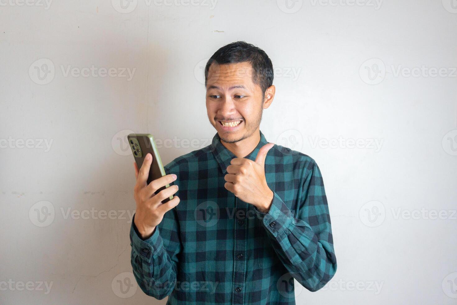 Young asian men is holding smartphone with happy expression in isolated white background photo