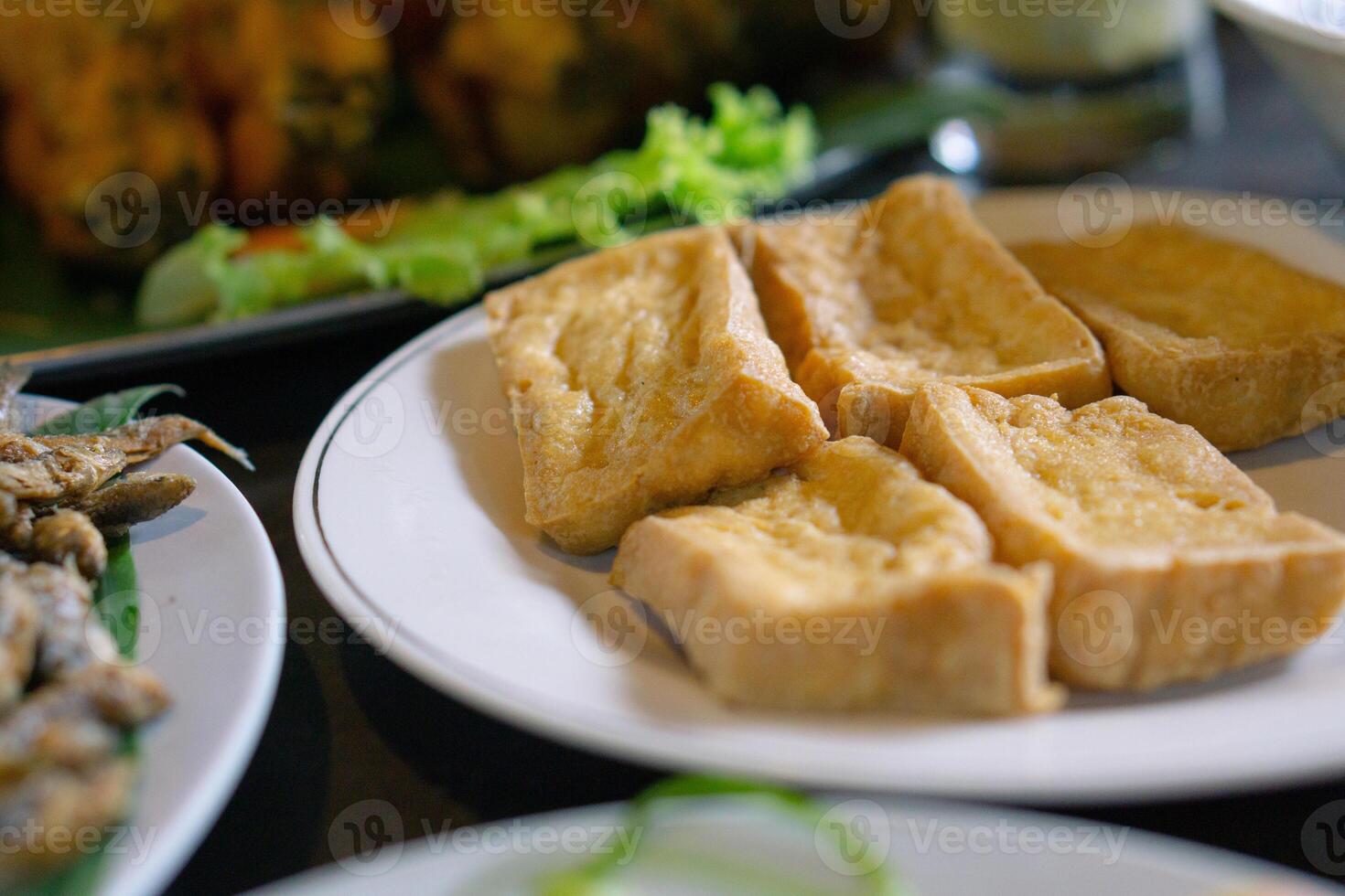 Tahu goreng or fried tofu prepared in white plate. Asian dish and Indonesia local food. photo