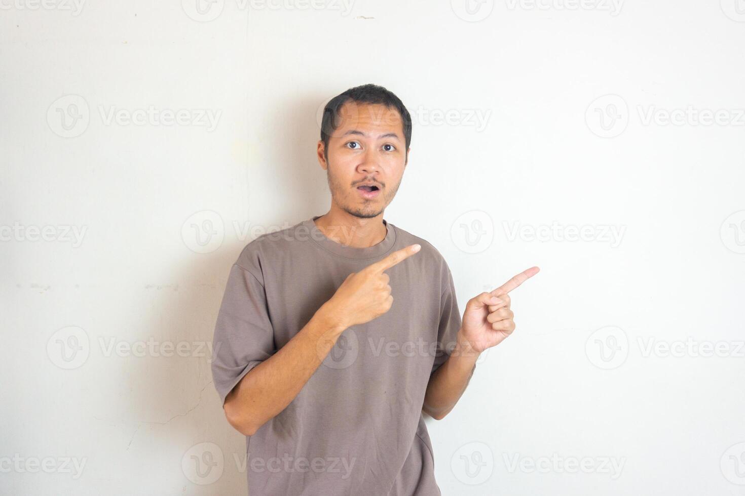 Young Adult Asian men pointing finger to the right with smiling face and exited expression with isolated white background photo