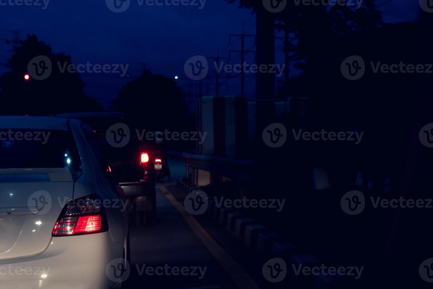 Blurred image rear sie view of cars on the road with turn on brake light at night. Environment of car at night with guard lens on the road. photo