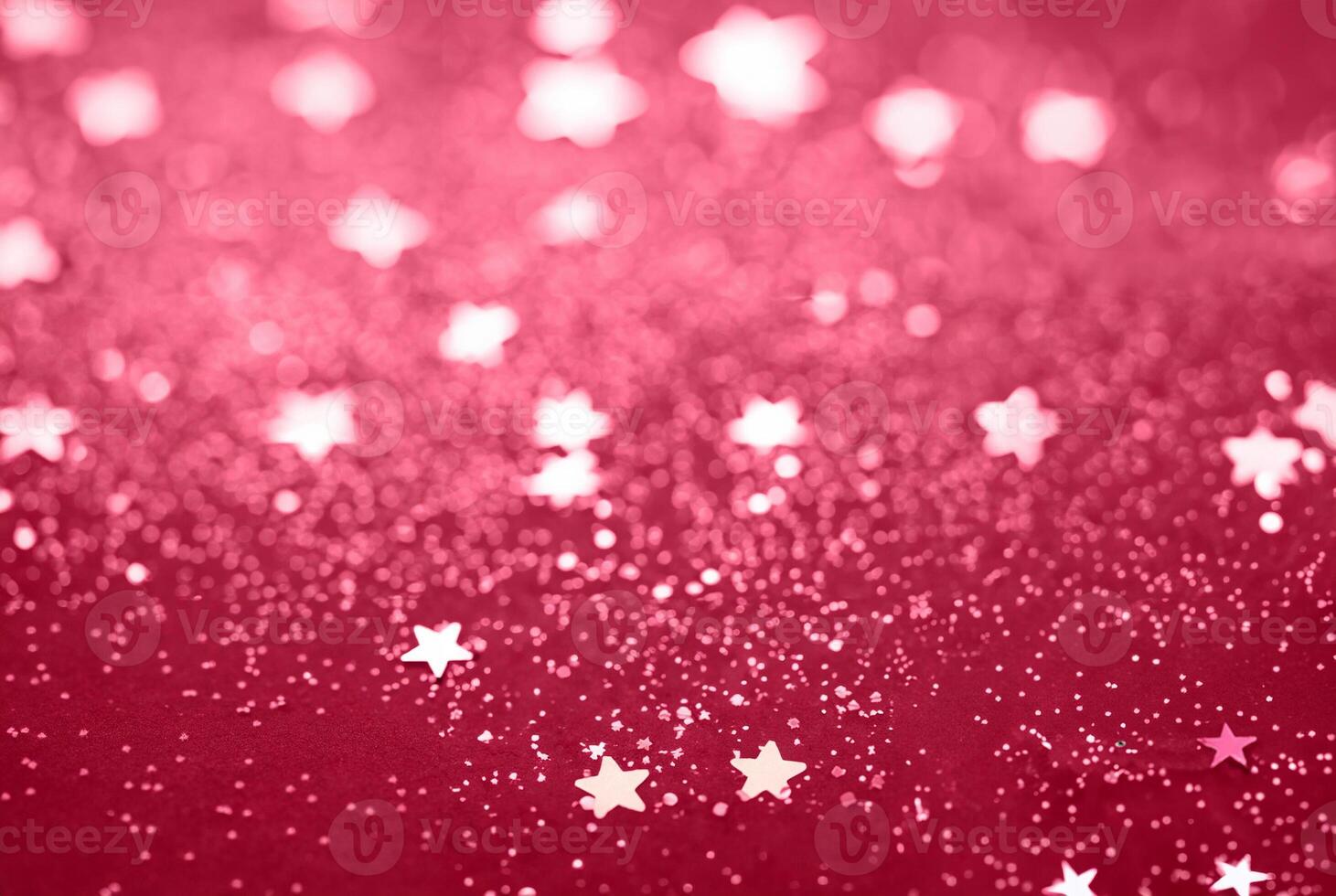 Abstract Glitter Background with Scattered Star Shaped Confetti on a Red Surface photo