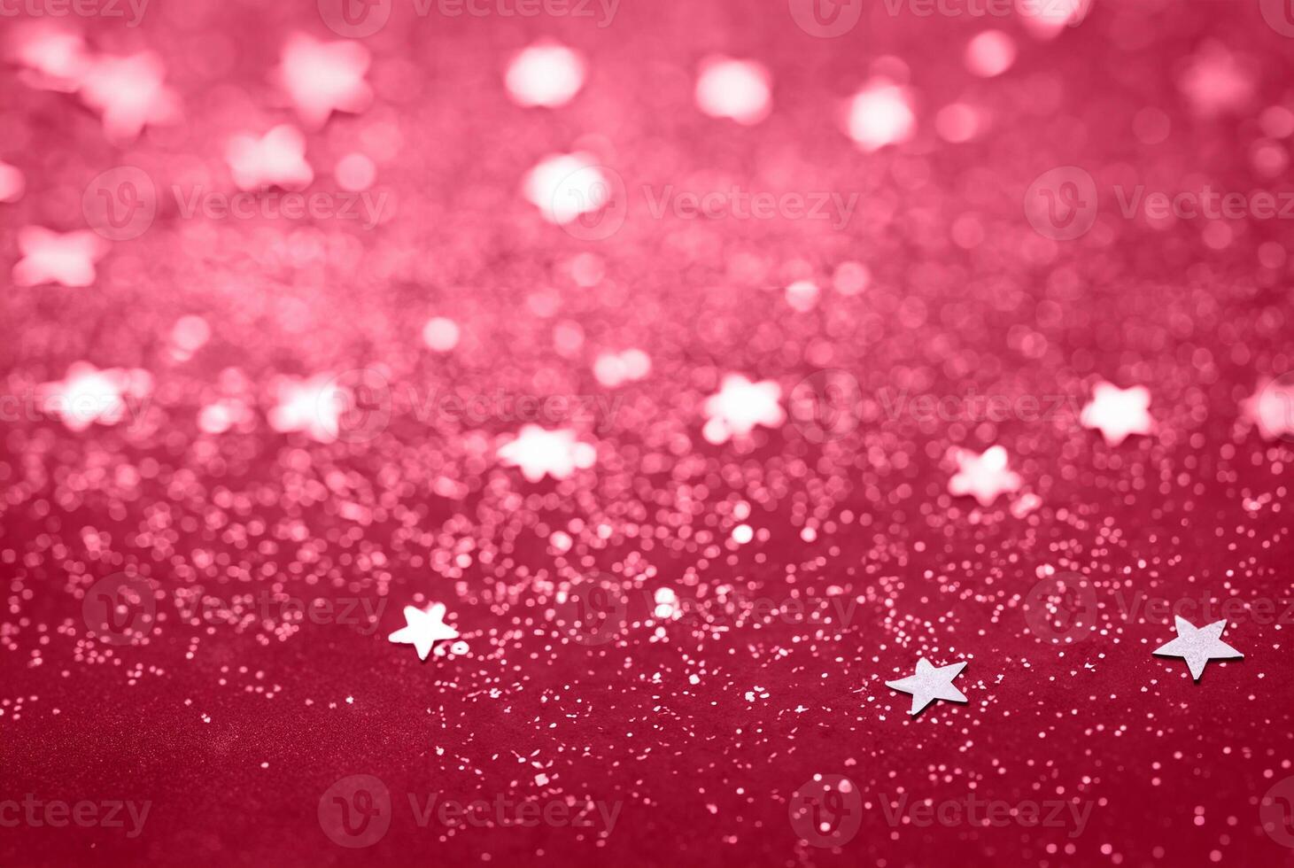 Abstract Glitter Background with Scattered Star Shaped Confetti on a Red Surface photo
