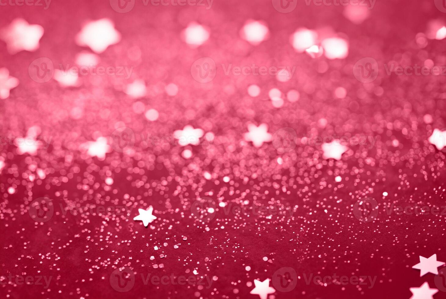Abstract Glitter Background with Scattered Star Shaped Confetti on a Red Surface photo