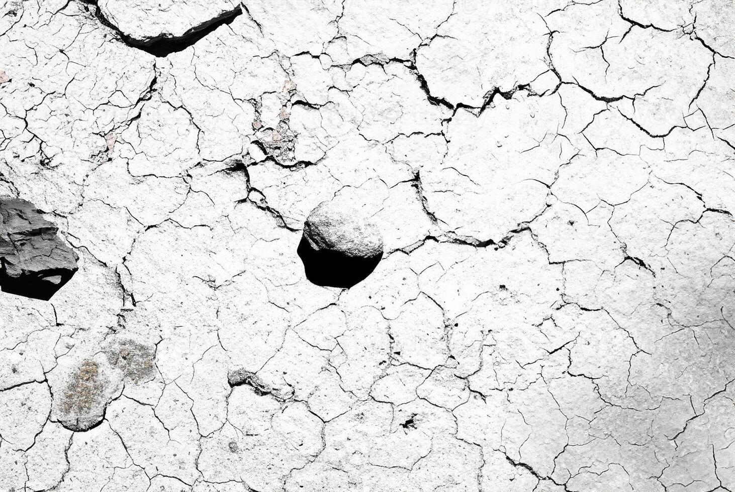 Close-up of a cracked and dry earth texture, showcasing natural patterns and rough surface, perfect for backgrounds or design elements. photo