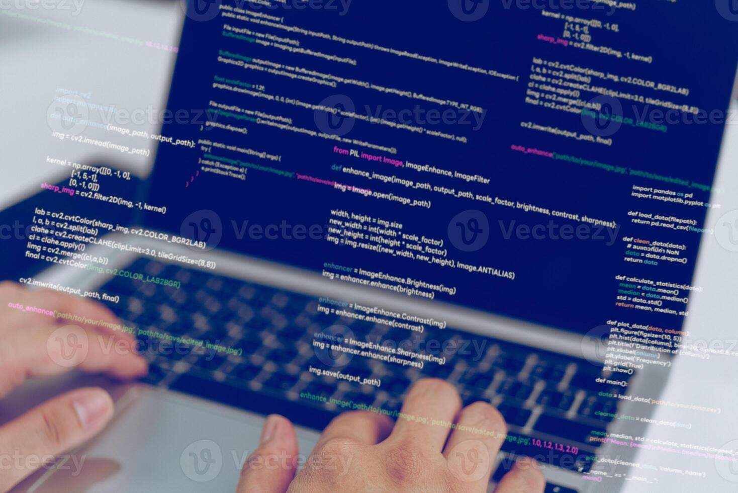A person typing on a laptop with code on it photo