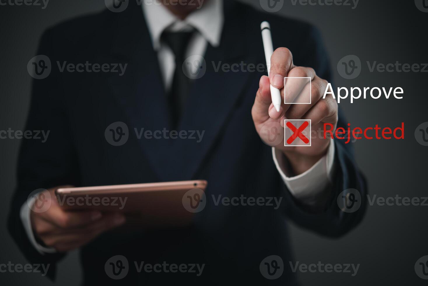 Man in suit holding tablet with approval and rejected text photo