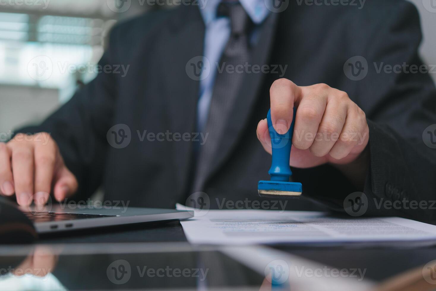 Hand stamping documents, symbolizing business approval and validation. Suitable for official contracts, corporate transactions, legal paperwork, administrative processes. photo