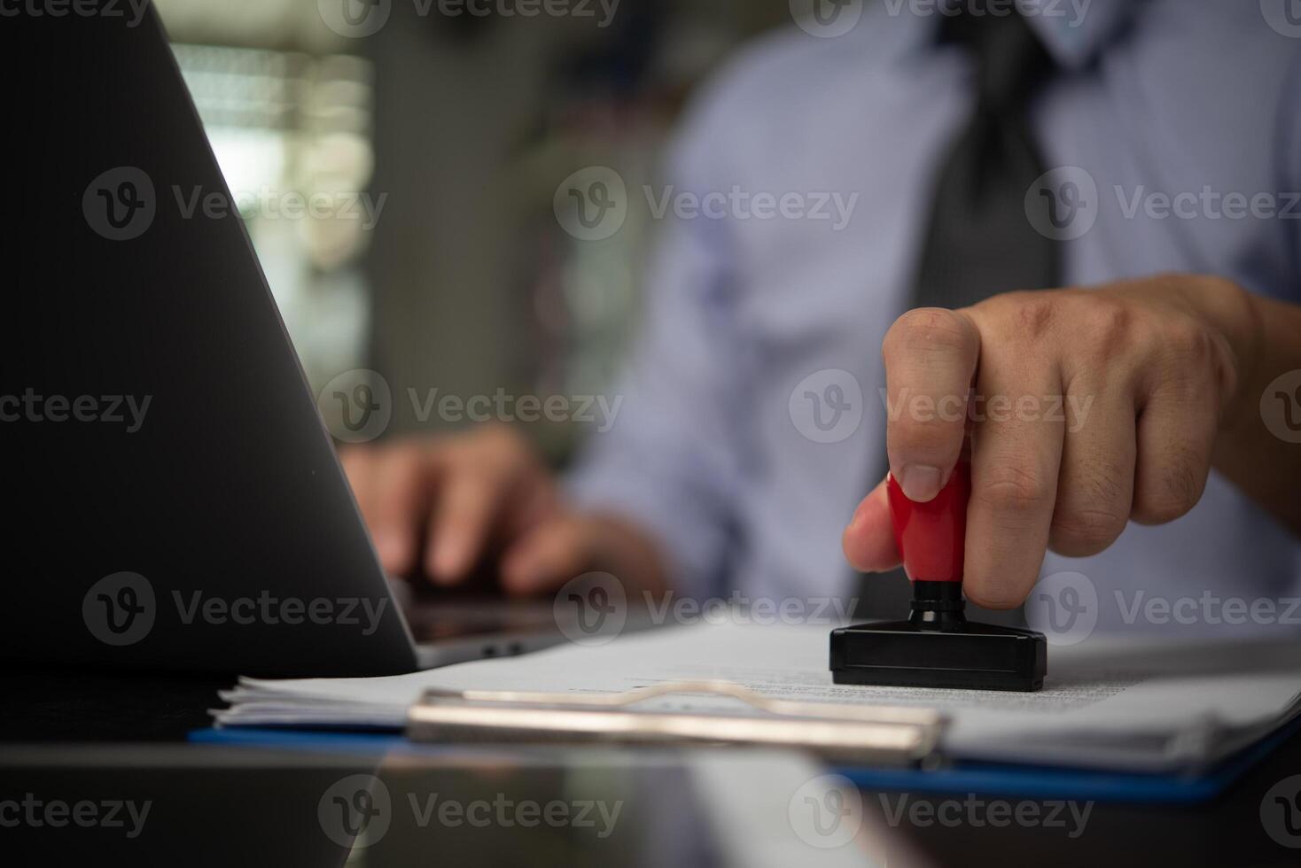 A person is using a rubber stamp to sign a document photo