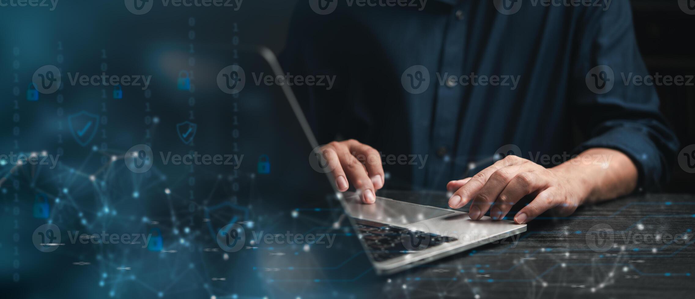 Focused professional working on cybersecurity strategies on laptop with digital security icons photo