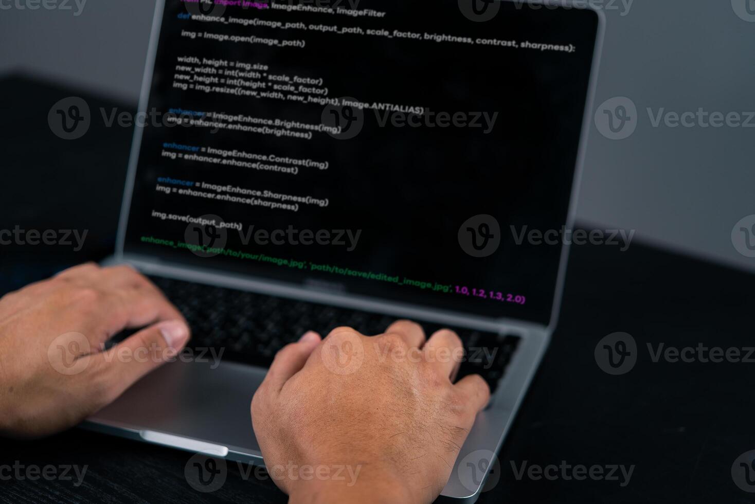 A person typing on a laptop with a programming program on it photo