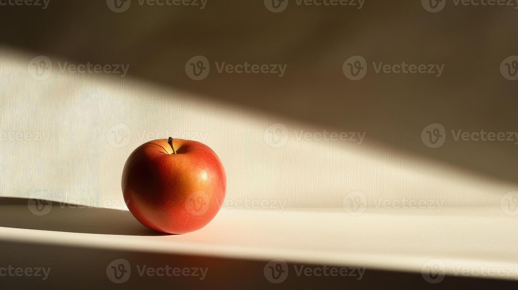 A Red Apple in a Beam of Sunlight on a White Surface photo