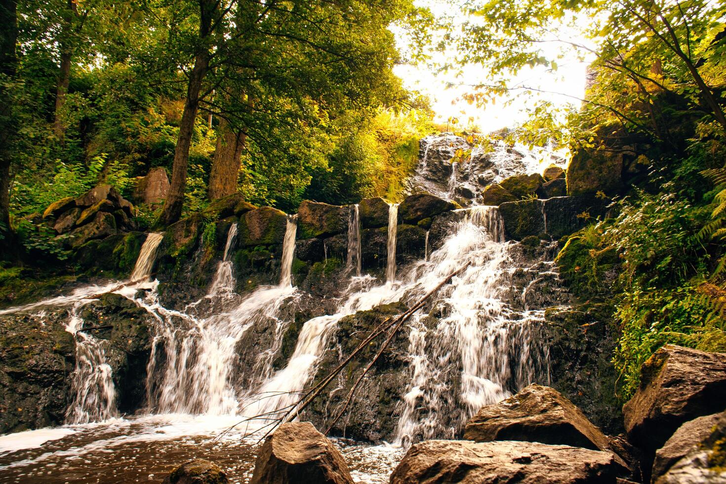 Small waterfall in Sweden in autumn. Moss-covered stones. Forest on the riverbank photo