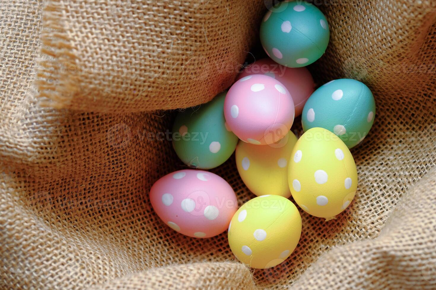 A Vibrantly Colorful Assortment of Easter Eggs Nestled Within a Rustic Burlap Basket photo
