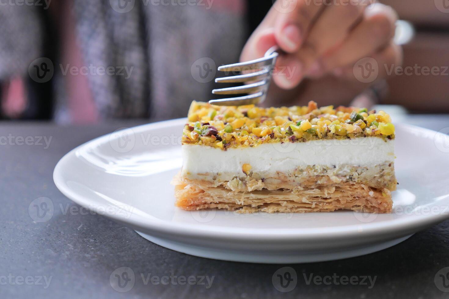 A Delicious Layered Dessert Artistically Arranged with Pistachios Presented on a Plate photo