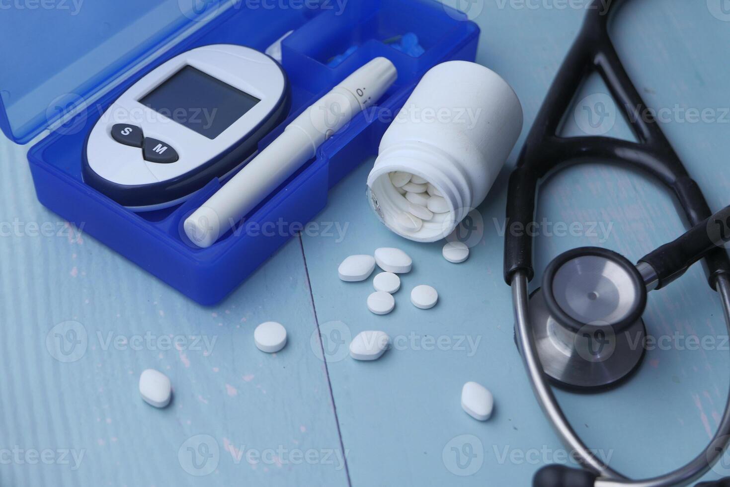 Essential Tools and Medications for Diabetes Management Presented on a Soft Blue Background photo