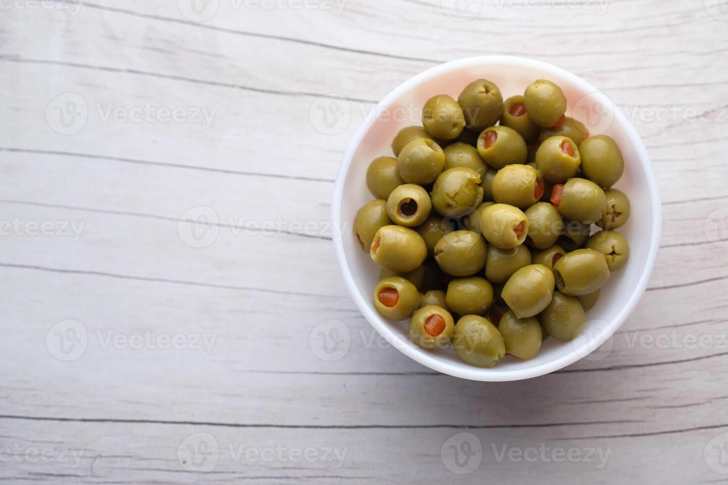 Savor the delightful taste of Green Olives combined with Pimientos served in a White Bowl photo