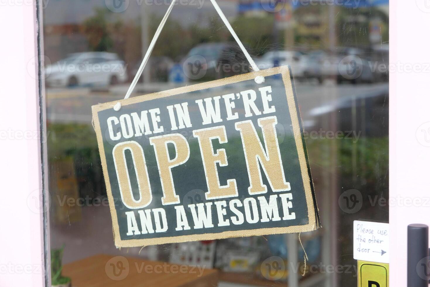 There is an Open and Awesome Sign displayed prominently at a Shop Entrance, attracting customers photo