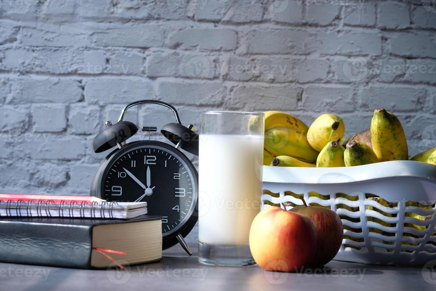 Morning Essentials to Start Your Day An Alarm Clock, Milk, Fresh Fruits, and Engaging Books photo