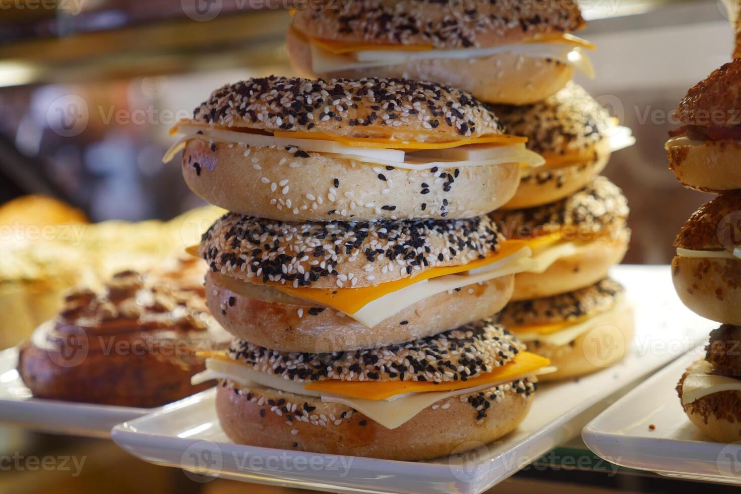 Stacked bagels topped with cheese and sesame seeds in a charming bakery display photo