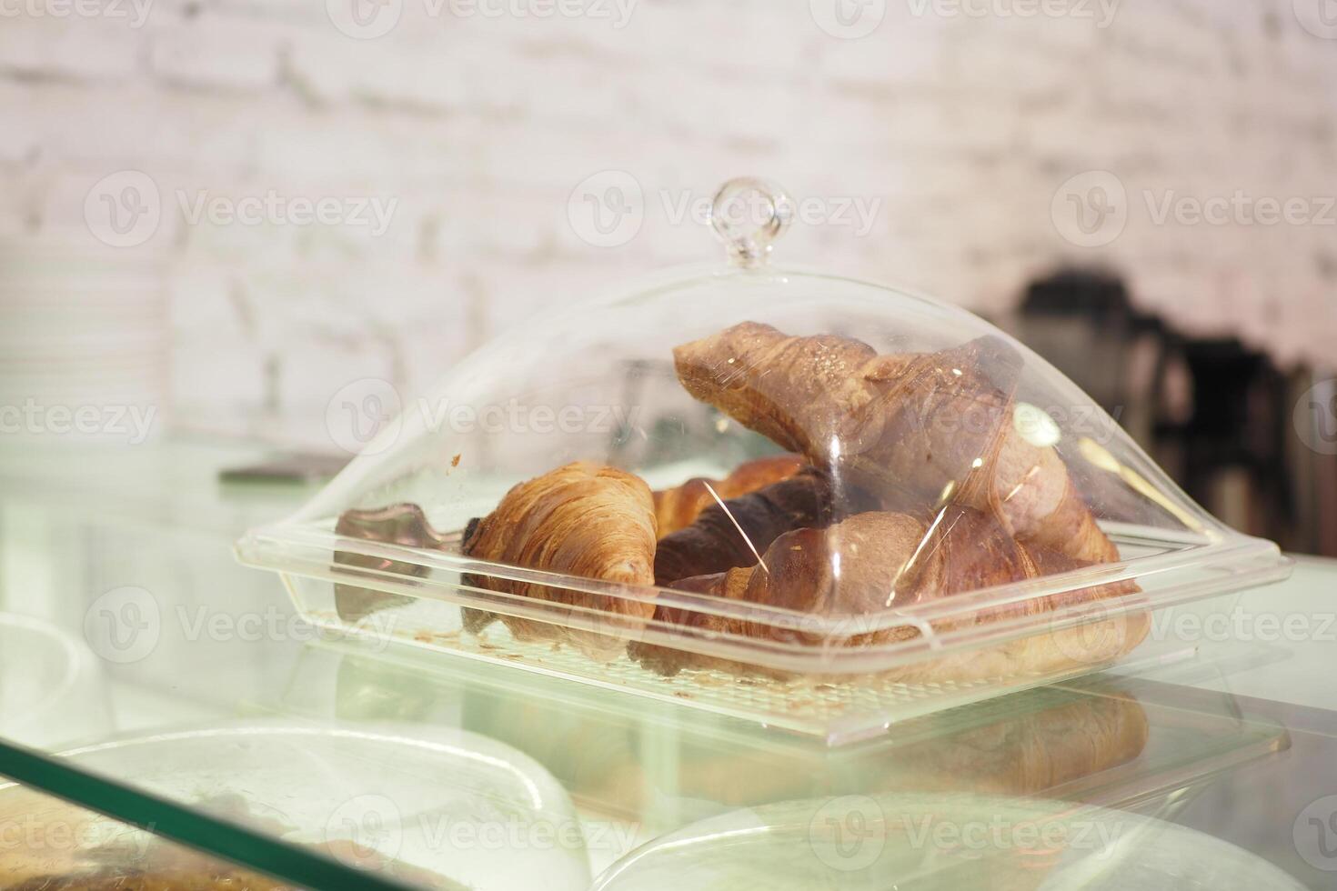 vertical sho or fresh baked croissant in a glass transparent container at shop photo