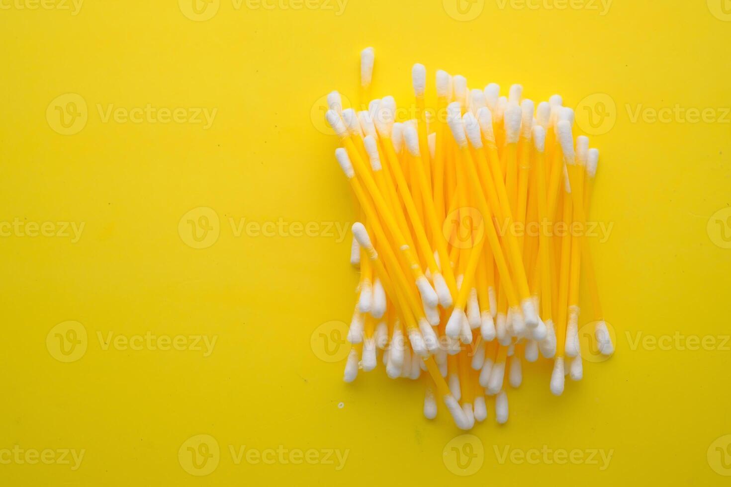 A vibrant arrangement of colorful Qtips displayed beautifully on a bright yellow background photo