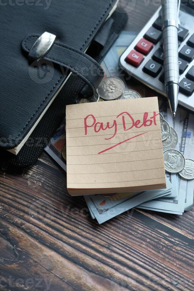 Financial Planning Pay Your Debt with a Reminder Note on Your Desk, Calculator, and Coins photo