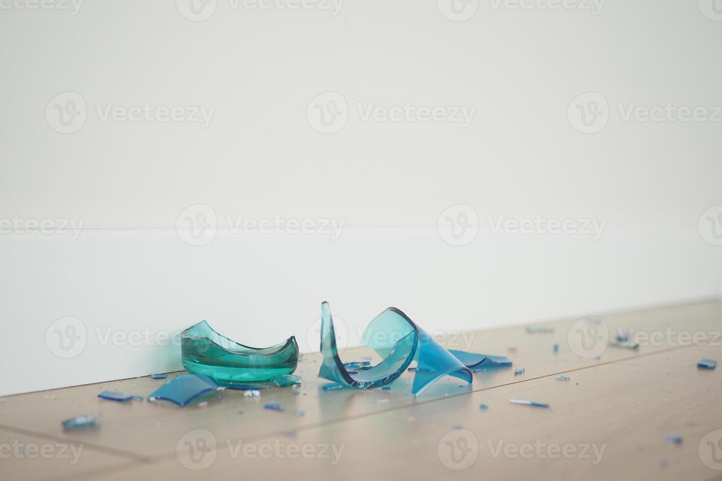 Scattered and Shattered Glass Pieces are Calmly Resting on a Beautiful Wooden Floor Surface photo