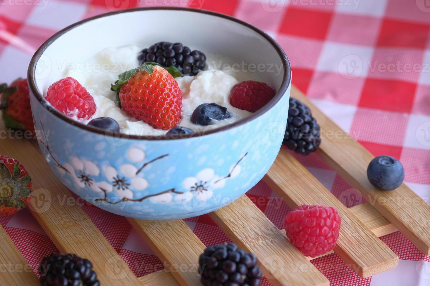 A delightful Fresh Berry Yogurt Bowl presented beautifully on a colorful Checkered Tablecloth photo