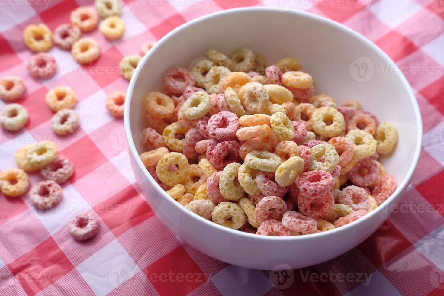 Colorful Breakfast Cereal in a White Bowl Positioned on a Checkered Tablecloth Surface photo