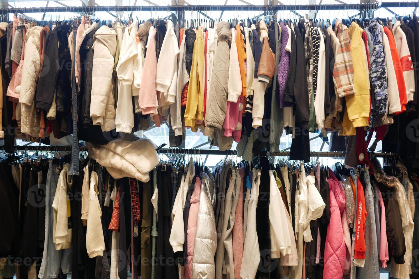 A Diverse and Colorful Collection of Clothing Beautifully Hanging on Racks for Display photo