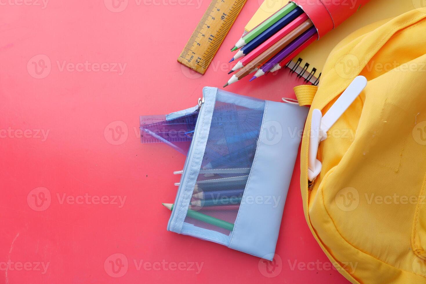 A Vibrant Array of Colorful School Supplies Placed Against a Bright Red Background photo