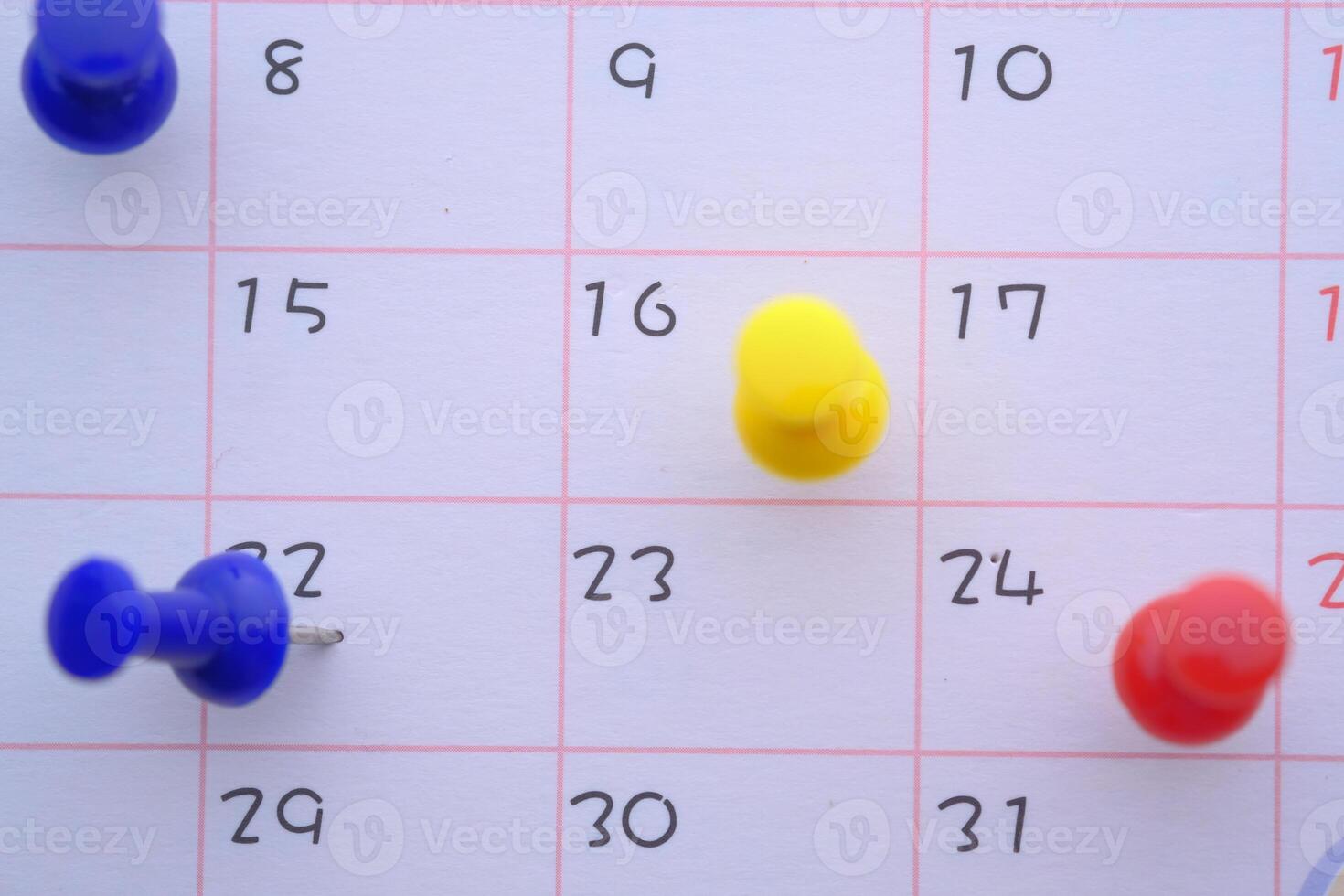 A vibrant assortment of Colorful Push Pins adorning a Calendar Page for effective planning photo