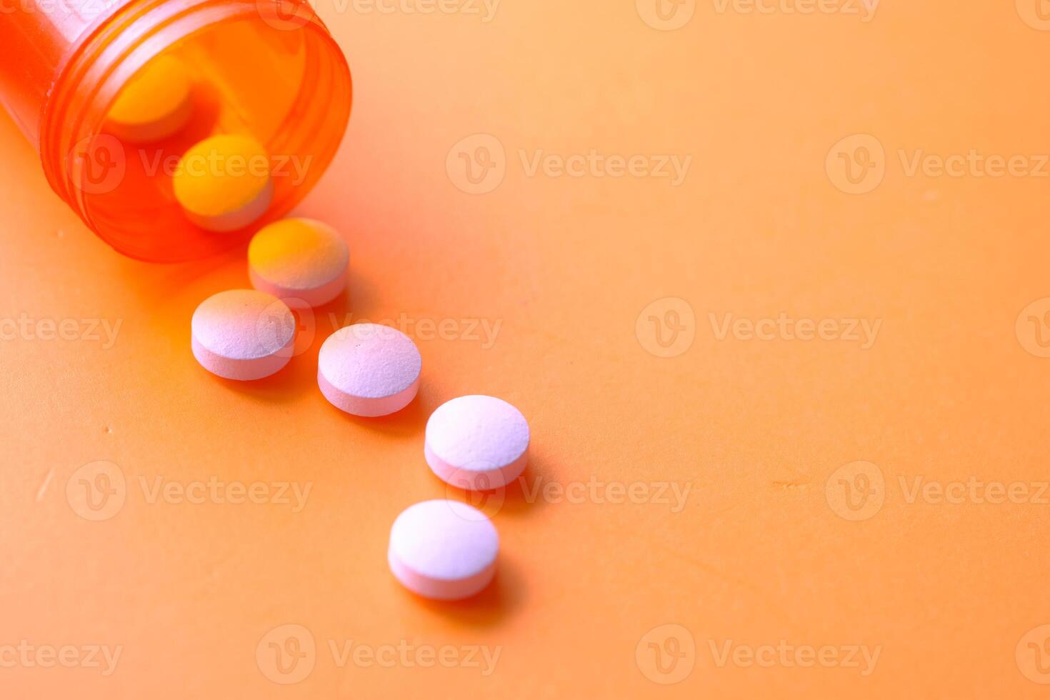 Spilled Pills from an Orange Prescription Bottle on a Bright and Colorful Background photo