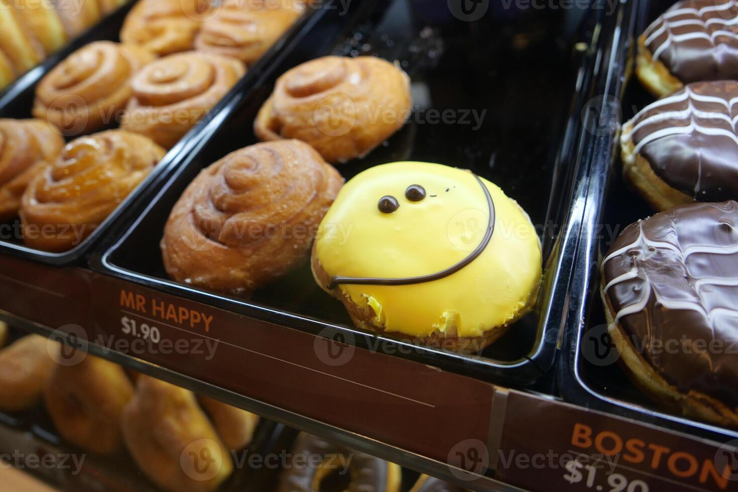 A Vibrant Array of Colorful Donuts and Delightful Sweet Treats on Display in a Bakery Case photo