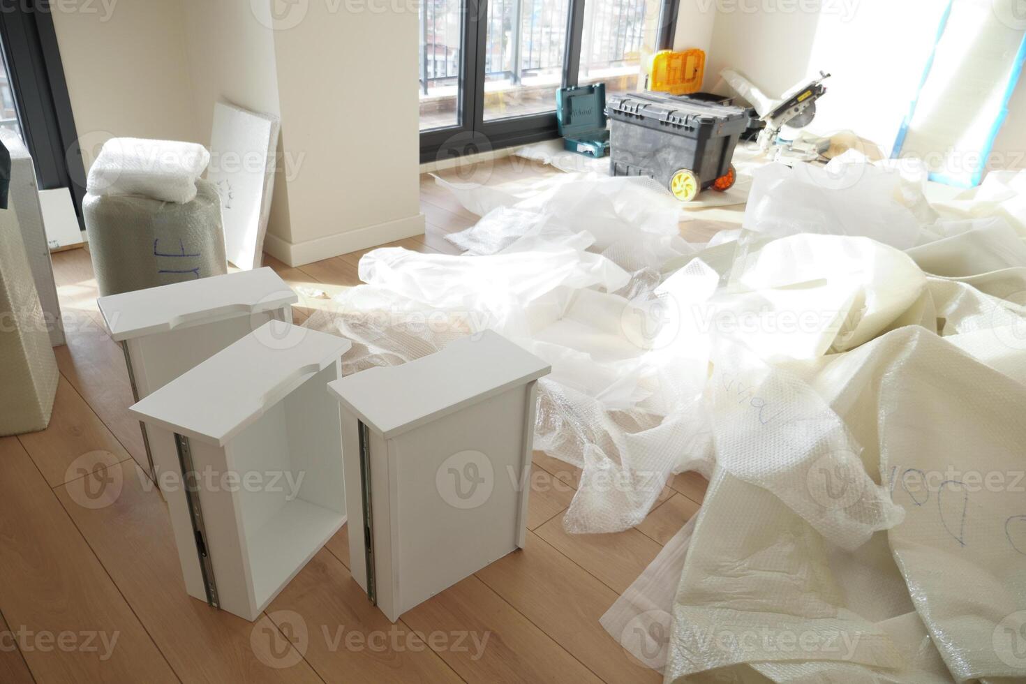 Unpacked Furniture in a Bright Room Filled with Various Renovation Materials for Use photo