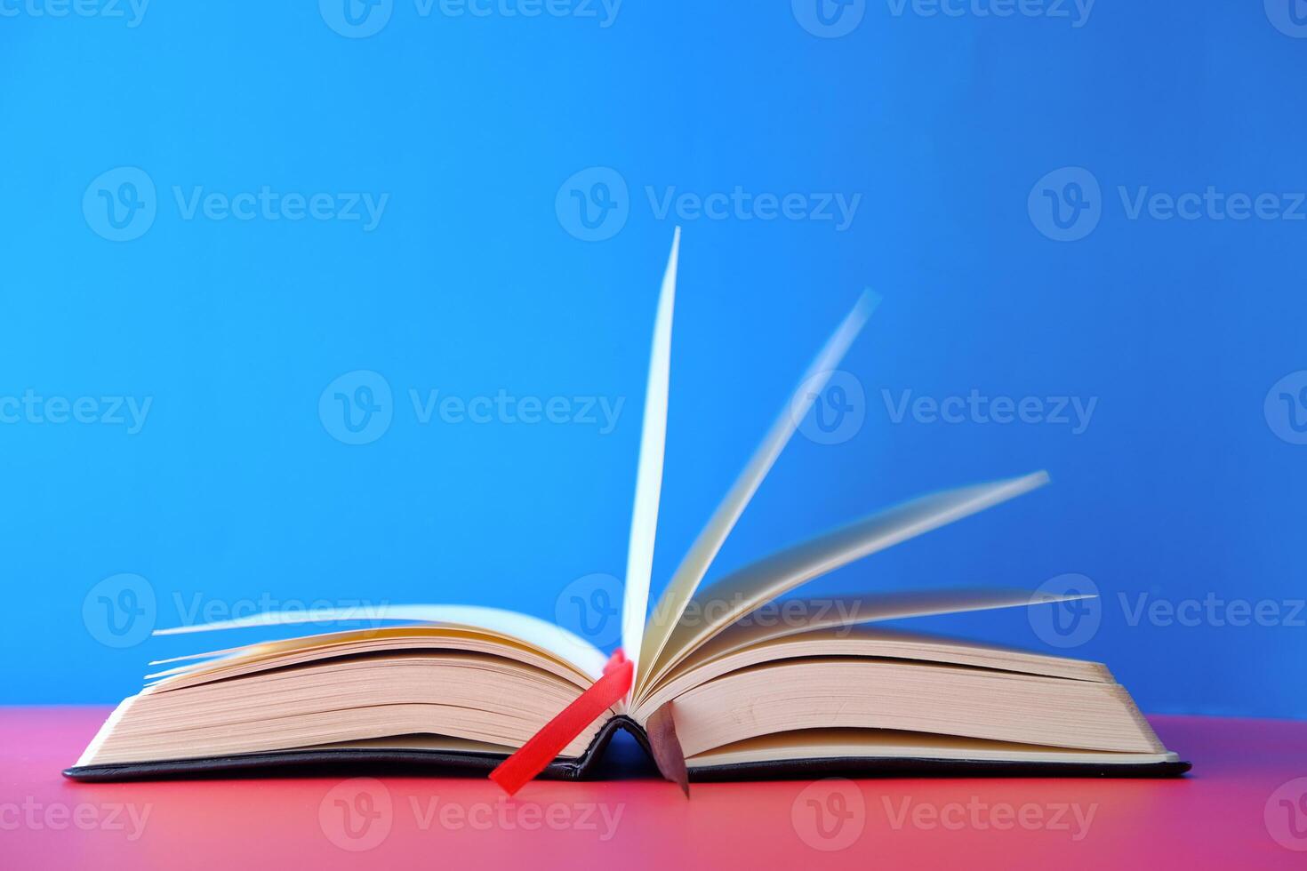 An Open Book with Pages Elegantly Turning Against a Bright and Colorful Background photo