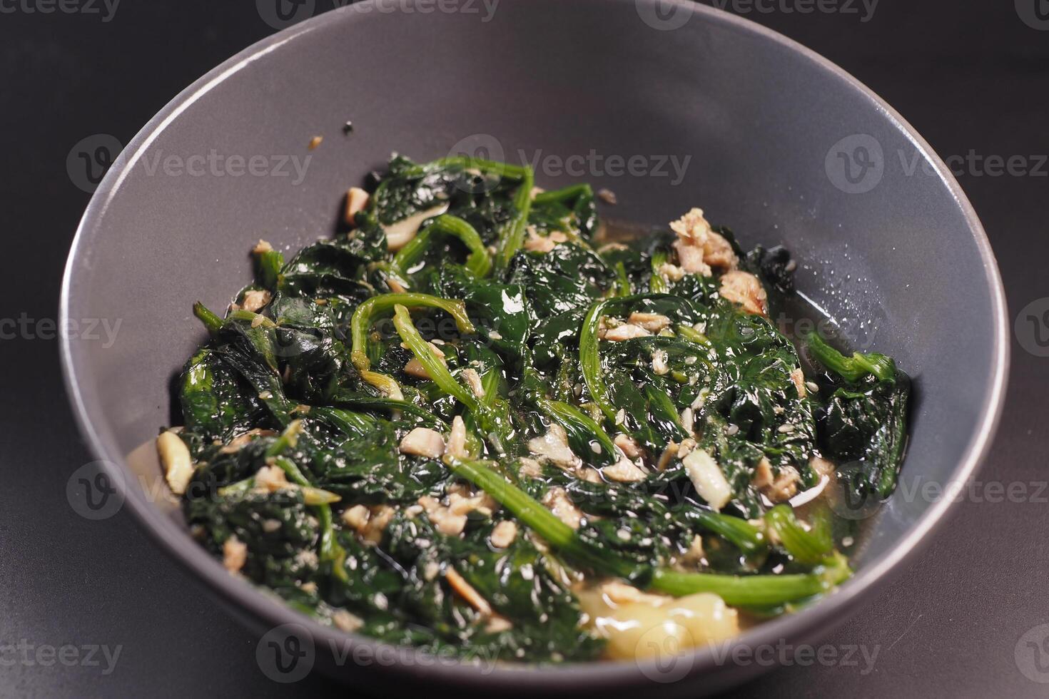 Top view of bowl with cooked spinach on table photo