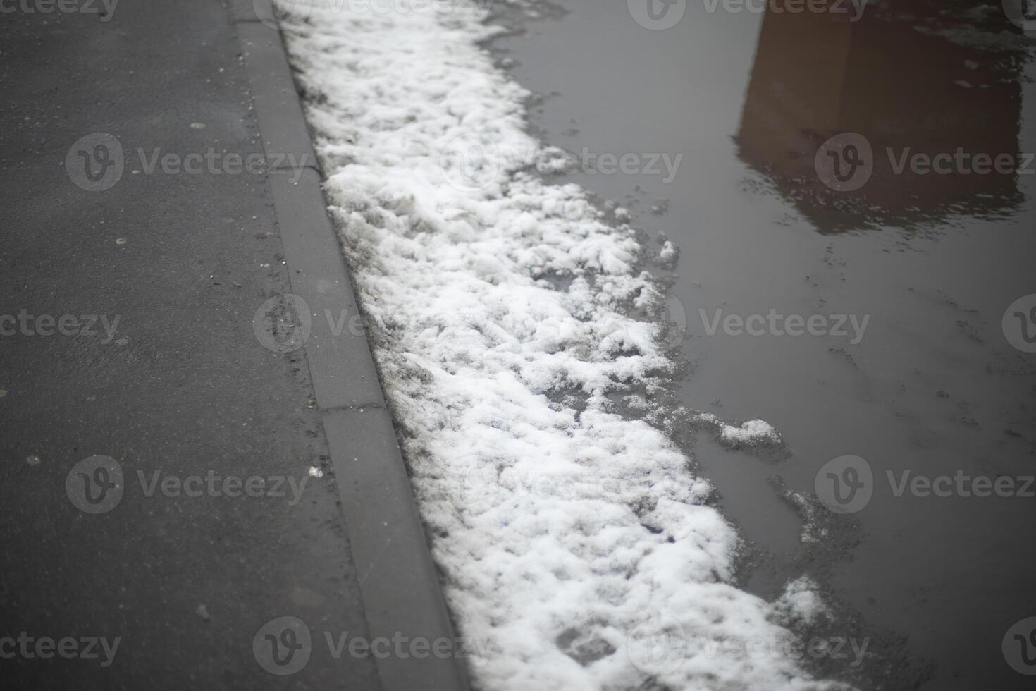 Melted snow on road. Large puddle in spring. Lots of water on asphalt. photo
