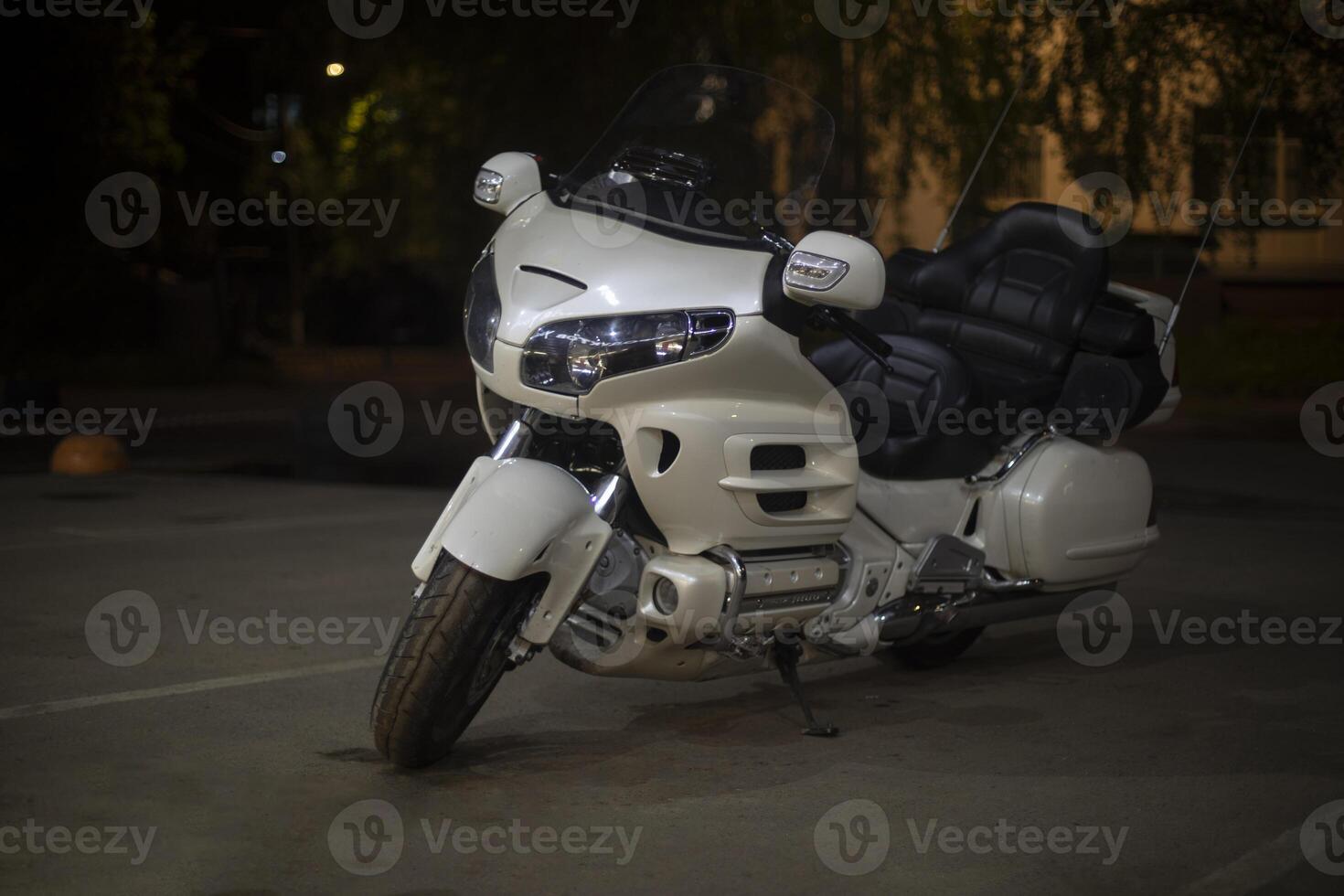 White motorcycle in the parking lot. Motorcycle at night. Personal transport. photo